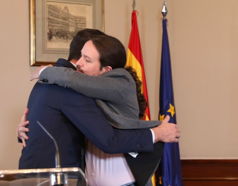 Pedro Sánchez and Pablo Iglesias hug after announcing the Socialist-Podemos coalition government deal (by Inma Mesa/PSOE)